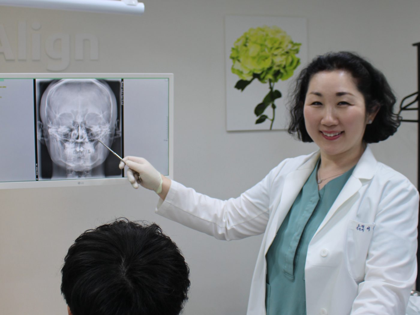Dr. Keun-Hye Lee reviewing a frontal skull X-ray with a patient